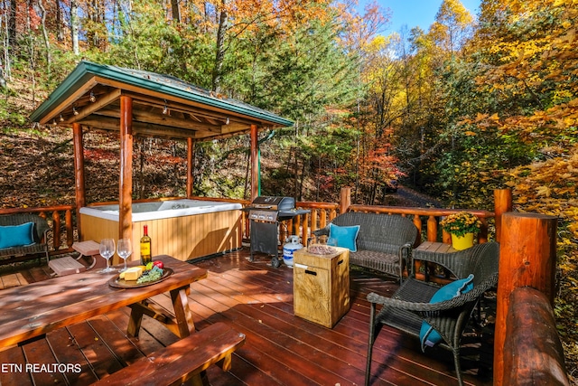 wooden deck with area for grilling and a hot tub