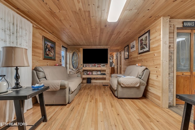 living room with wood ceiling, wooden walls, and light hardwood / wood-style flooring