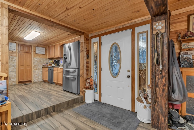 entrance foyer featuring light hardwood / wood-style flooring, wood ceiling, and wooden walls