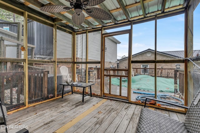 unfurnished sunroom with ceiling fan