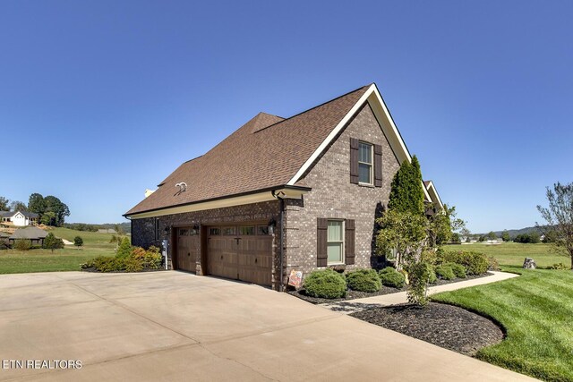 view of home's exterior featuring concrete driveway, brick siding, a garage, a yard, and a shingled roof
