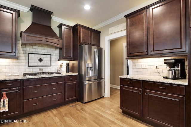 kitchen featuring custom exhaust hood, light wood-type flooring, ornamental molding, backsplash, and appliances with stainless steel finishes