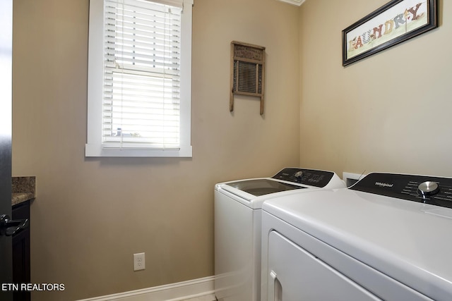 clothes washing area featuring cabinet space, washing machine and clothes dryer, and baseboards