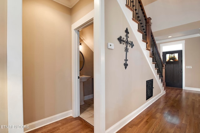 hallway with wood-type flooring and crown molding