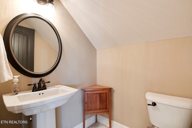 bathroom with lofted ceiling and toilet