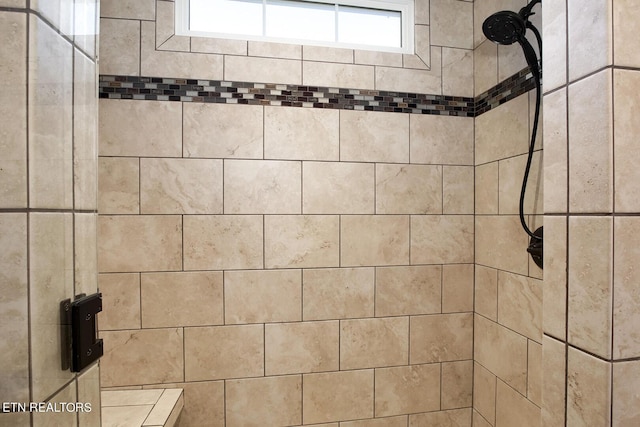 interior details featuring tiled shower