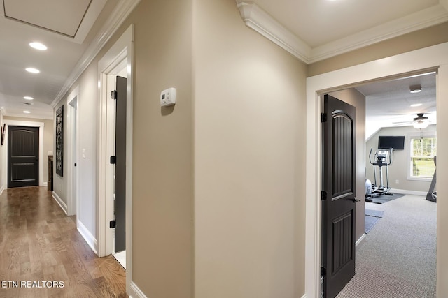 hall with recessed lighting, light wood-style floors, baseboards, and ornamental molding