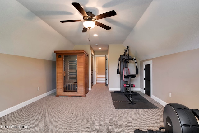 exercise room featuring lofted ceiling, ceiling fan, and dark carpet