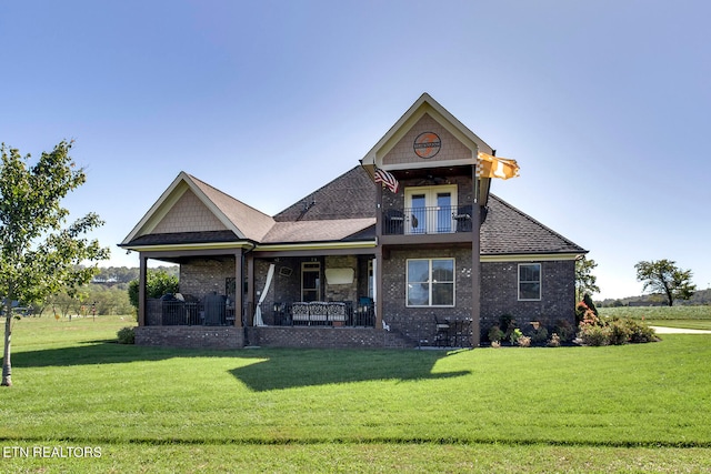 view of front of home with a front yard, a balcony, and a porch