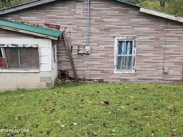 view of side of home with a yard