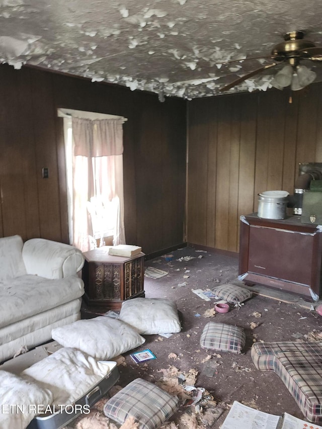 unfurnished living room featuring wood walls and ceiling fan