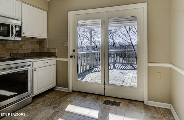 doorway featuring baseboards and visible vents