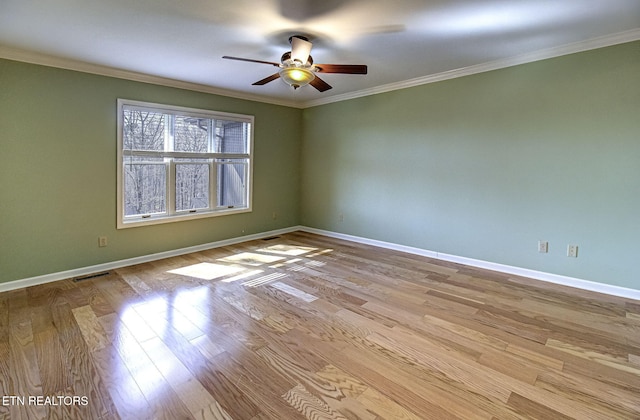 unfurnished room featuring ornamental molding, baseboards, and wood finished floors