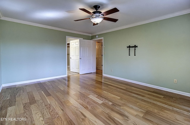 spare room featuring ornamental molding, ceiling fan, baseboards, and wood finished floors