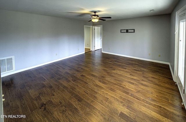 empty room featuring dark wood finished floors, baseboards, visible vents, and a ceiling fan