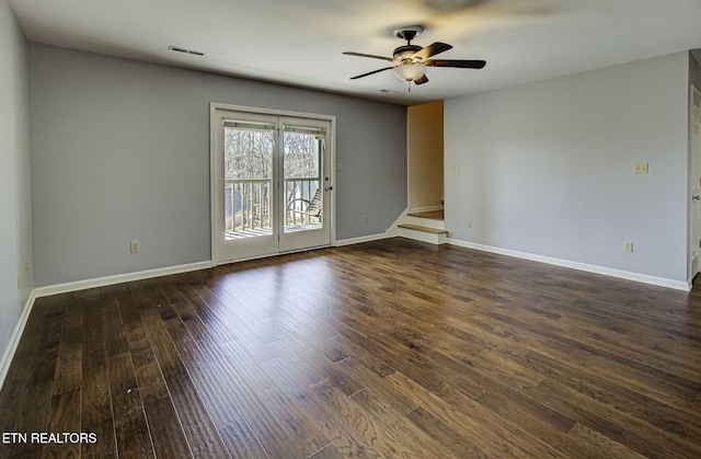 empty room featuring visible vents, baseboards, dark wood-type flooring, and a ceiling fan