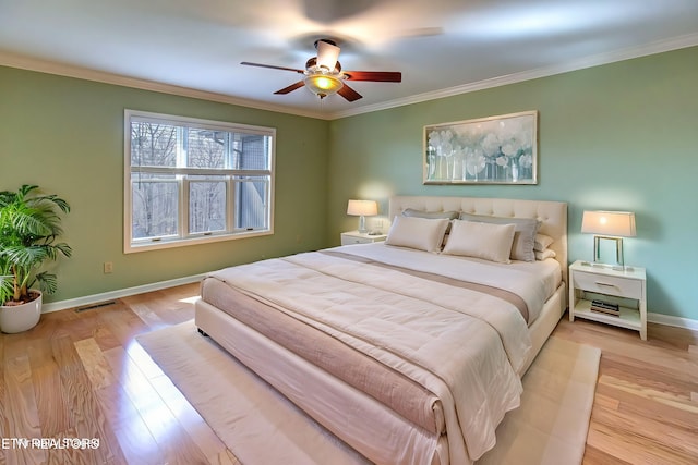 bedroom with wood finished floors, baseboards, and ornamental molding