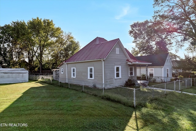 back of property featuring a storage shed and a lawn