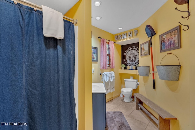 bathroom featuring tile patterned flooring, curtained shower, vanity, and toilet