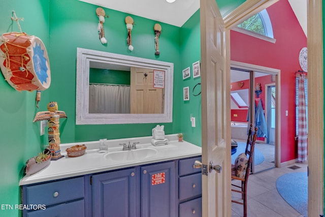 bathroom featuring lofted ceiling, tile patterned flooring, and vanity