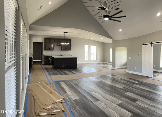 living room featuring a barn door, visible vents, recessed lighting, ceiling fan, and high vaulted ceiling