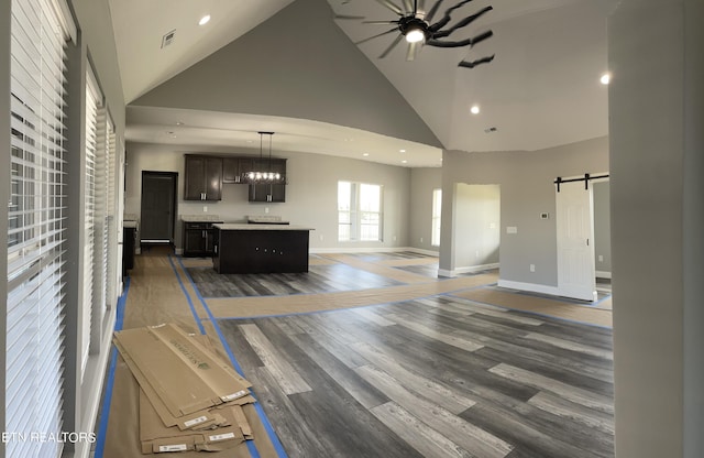 living area featuring a barn door, recessed lighting, visible vents, high vaulted ceiling, and ceiling fan