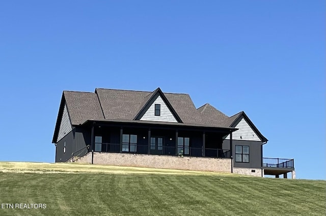 rear view of property featuring a lawn