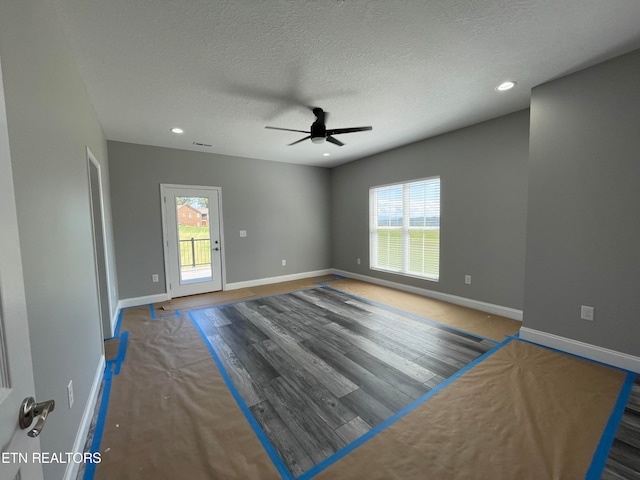 unfurnished room with hardwood / wood-style floors, ceiling fan, and plenty of natural light