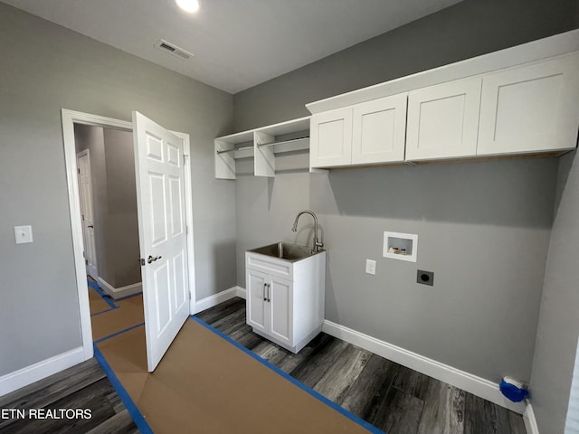 laundry area featuring visible vents, a sink, electric dryer hookup, washer hookup, and dark wood-style flooring