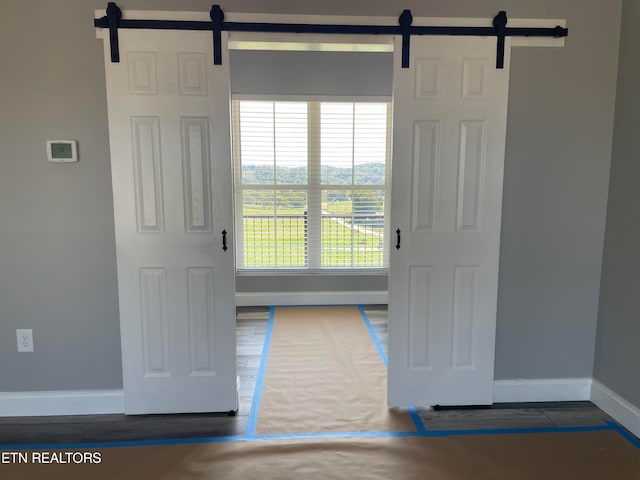 entryway featuring a barn door and dark hardwood / wood-style floors