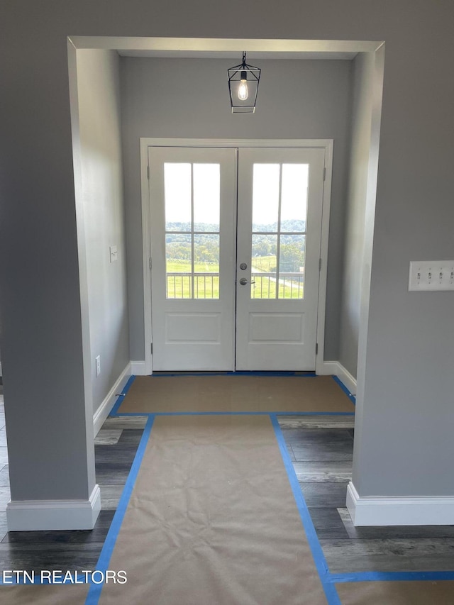 doorway with baseboards, french doors, and wood finished floors