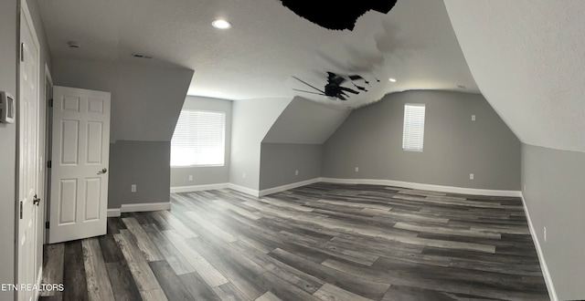 bonus room featuring ceiling fan, a textured ceiling, lofted ceiling, and dark hardwood / wood-style flooring