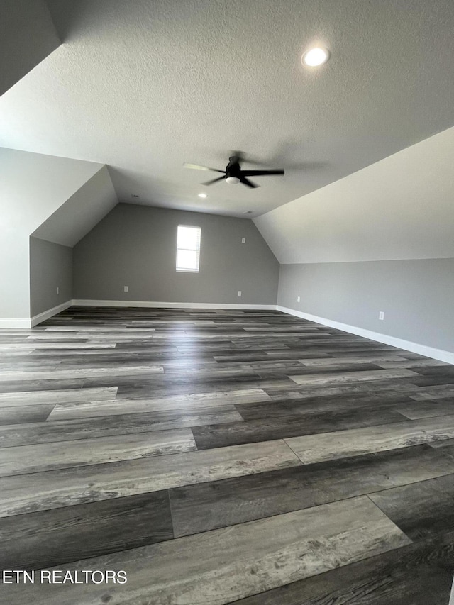 bonus room with lofted ceiling, wood finished floors, a ceiling fan, and baseboards
