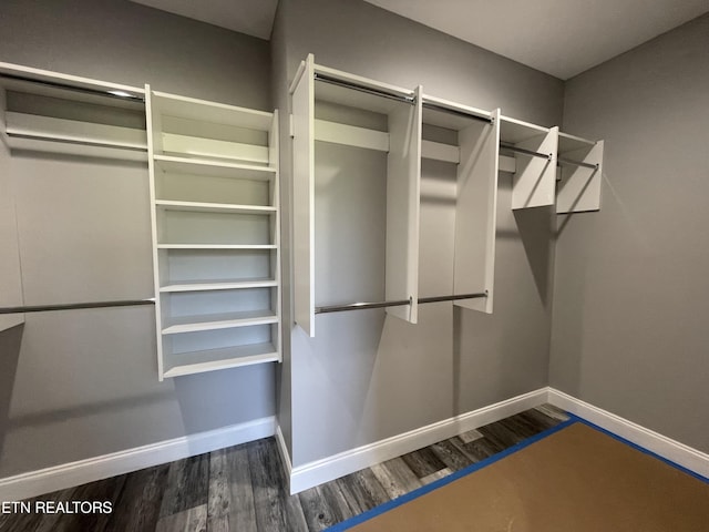 walk in closet with wood finished floors