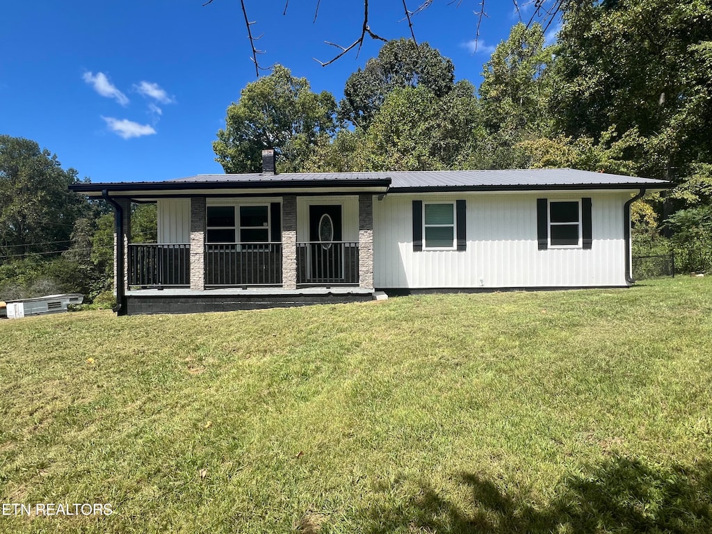 single story home with covered porch and a front yard