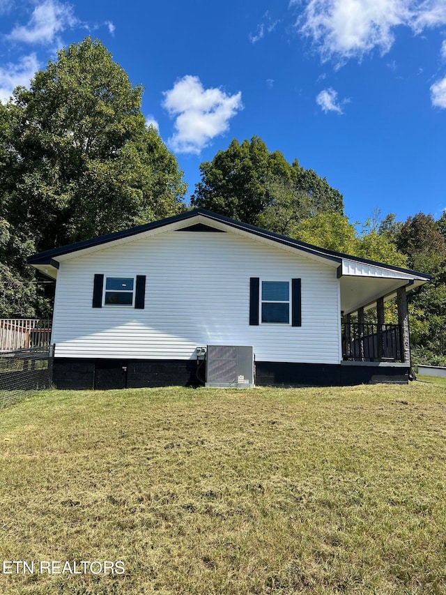 view of front of house featuring a front lawn and central AC