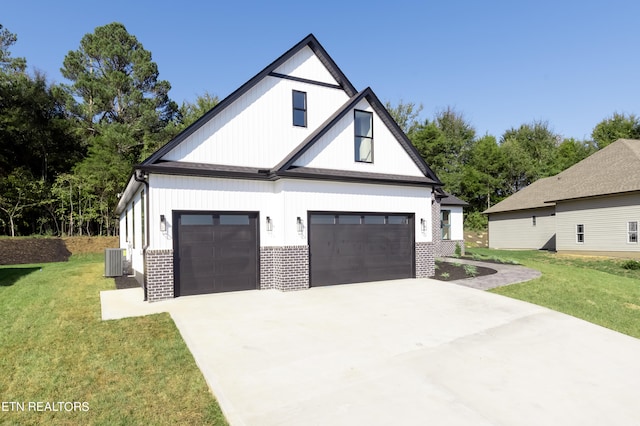 view of front of home with a garage, cooling unit, and a front lawn