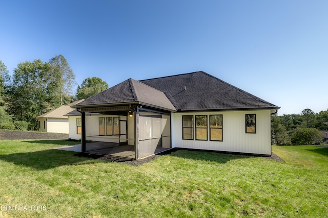 back of property featuring a patio area, a lawn, and roof with shingles