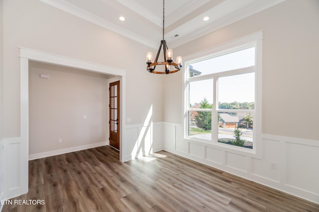 unfurnished dining area featuring a chandelier, a decorative wall, recessed lighting, wood finished floors, and ornamental molding