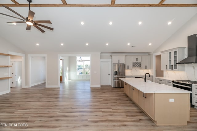 kitchen with light wood-style flooring, stainless steel appliances, open floor plan, wall chimney range hood, and a large island