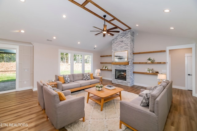 living area with ceiling fan, light wood finished floors, a fireplace, and visible vents