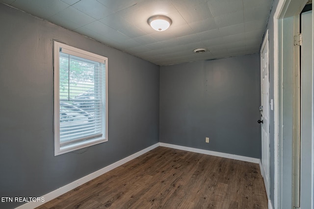 empty room with dark hardwood / wood-style flooring