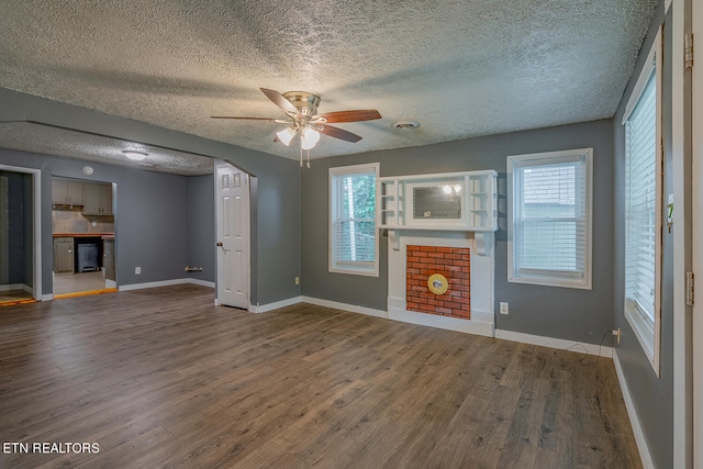 unfurnished living room featuring ceiling fan, a textured ceiling, and hardwood / wood-style floors