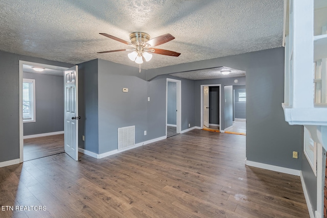 unfurnished room featuring a textured ceiling, dark hardwood / wood-style flooring, and ceiling fan