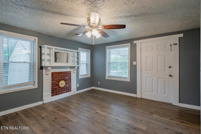 foyer with ceiling fan, a textured ceiling, dark wood-type flooring, and a wealth of natural light