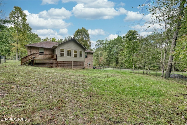 back of property with a lawn and a deck