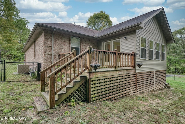 rear view of house with a yard and a deck