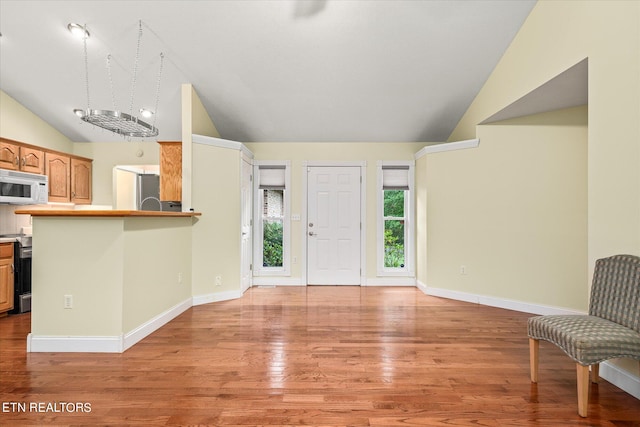 entrance foyer featuring light hardwood / wood-style floors, an inviting chandelier, and high vaulted ceiling