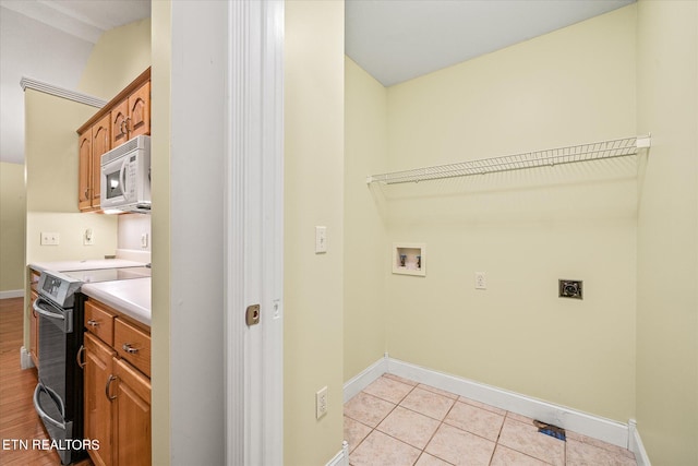 laundry room featuring washer hookup, light tile patterned flooring, and hookup for an electric dryer