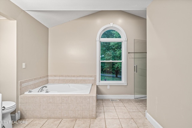 bathroom featuring toilet, lofted ceiling, tiled bath, and tile patterned floors